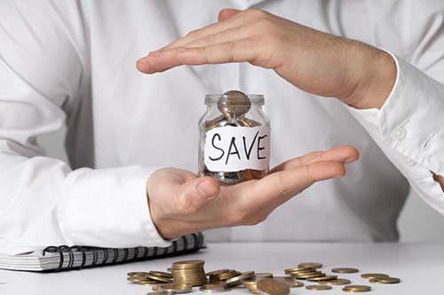 Person holding a small jar with save label filled with coins