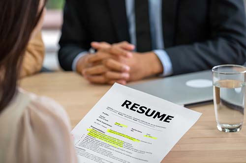 Young woman with a resume in hand, conducting interviews with applicants