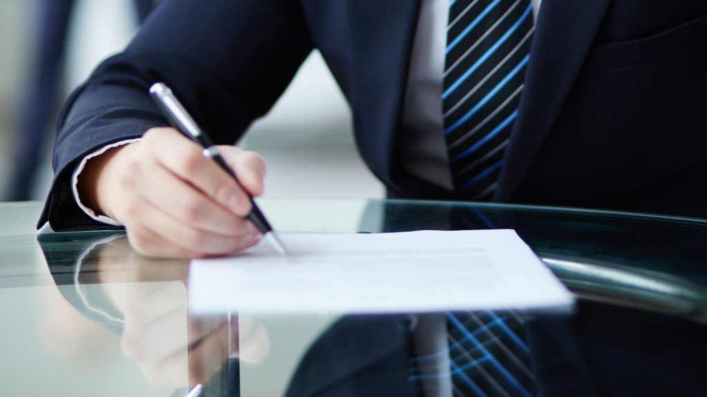 shot of an employee's hand signing his contract